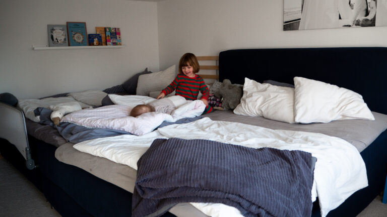Ein bedürfnisorientiertes Familienbett mit Baby und Kleinkind